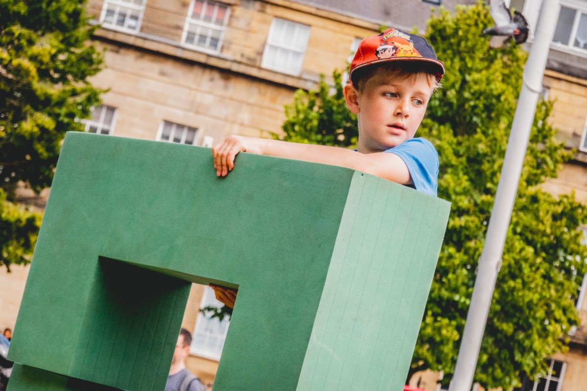 A child holding a foam shape from Play Rebellion